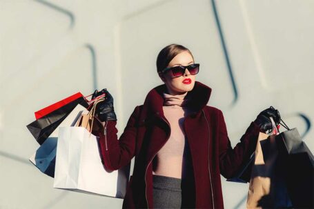 Frau mit vielen Shoppingtaschen in den Händen