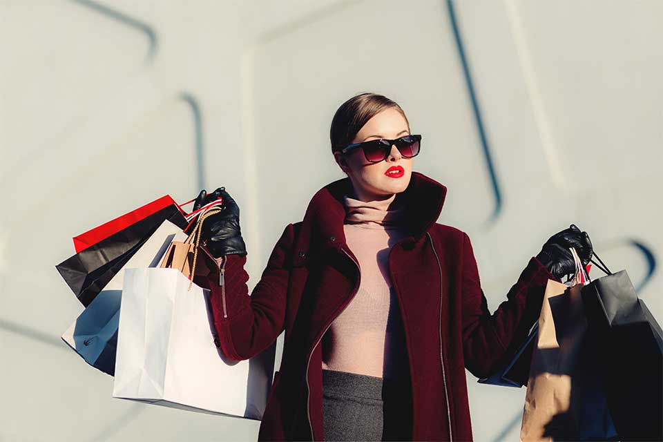 Frau mit vielen Shoppingtaschen in den Händen