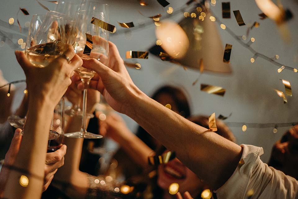 Feiernde Menschen beim Anstoßen mit Sekt